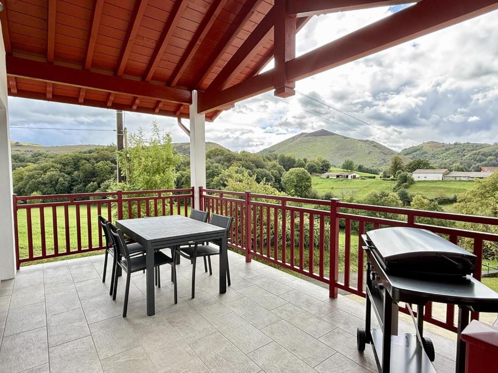 a patio with a table and chairs on a balcony at Karrika buria in Saint-Martin-dʼArberoue