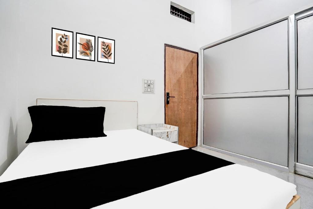 a bedroom with a bed and a large window at Hotel O Wave Inn in Jahāngīrpur