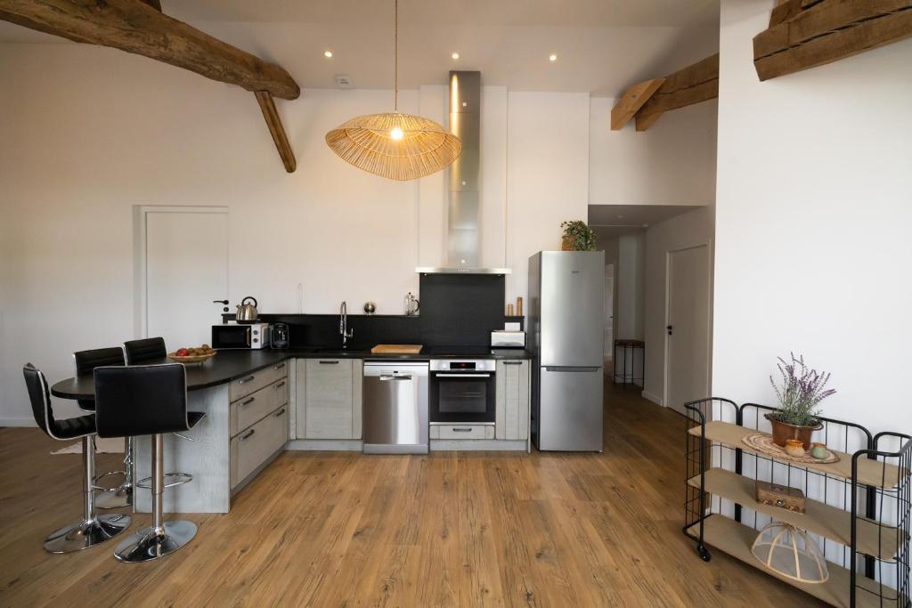 Una cocina con refrigerador y una mesa y sillas. en Le gite d'etxerria, en Arhansus