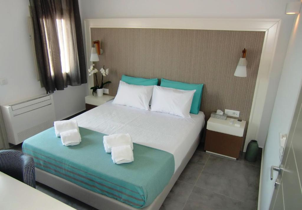 1 dormitorio con 1 cama con almohadas azules y blancas en Platia, en Fira