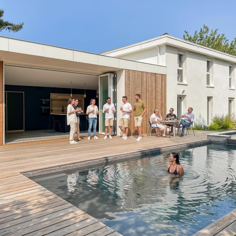 a group of people standing in the swimming pool of a house at Villa calme avec piscine et spa à Mérignac Proche hôpital tram et parc d activité in Mérignac