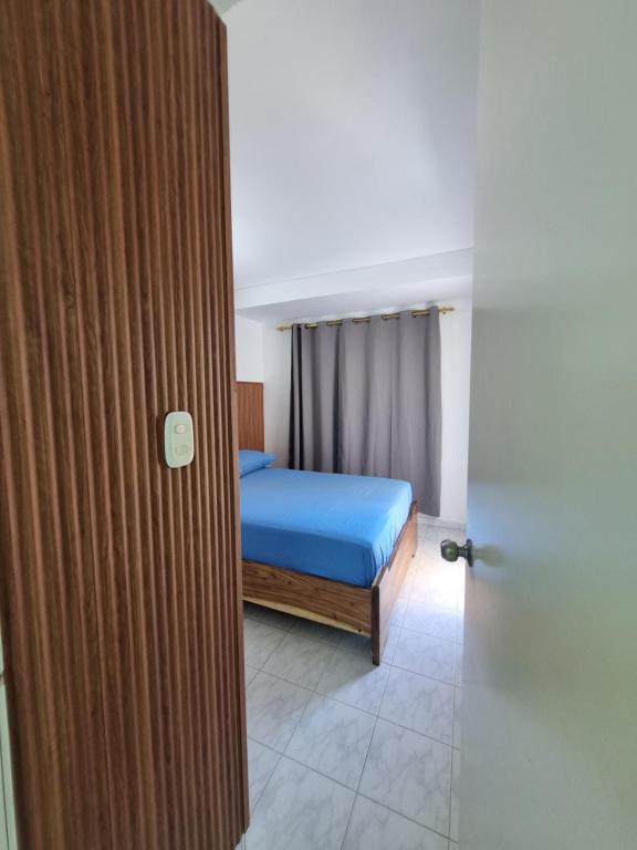 a bedroom with a blue bed and a door at Casa Narad Valledupar in Valledupar