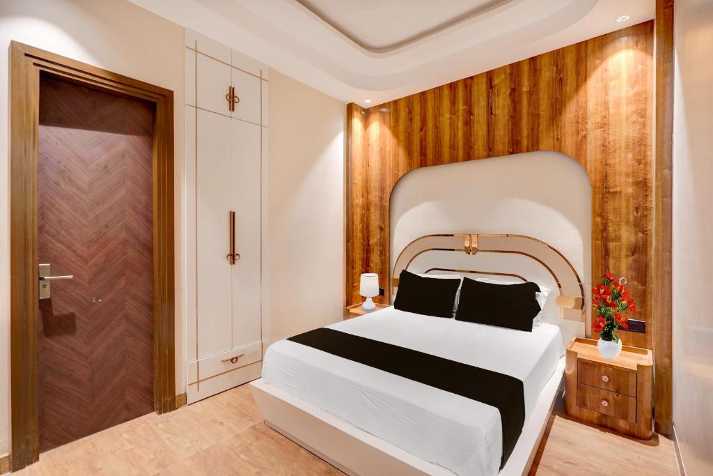 a bedroom with a white bed and a wooden wall at Hotel O Parth in Ayodhya
