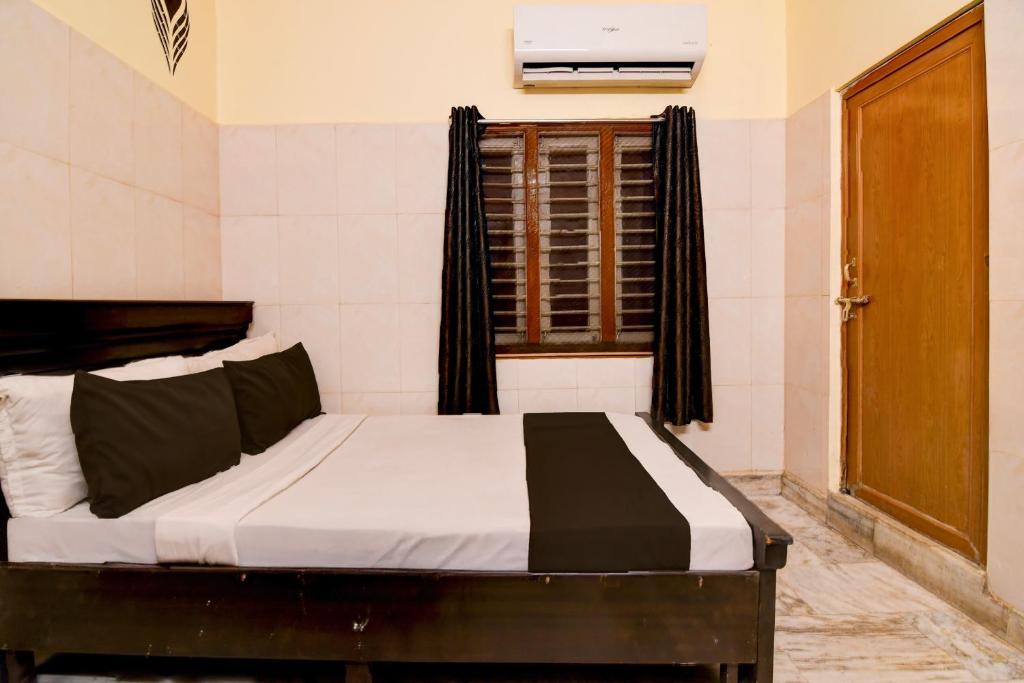 a bed in a room with a window and a window at Hotel O D Stay Inn in Rushikonda