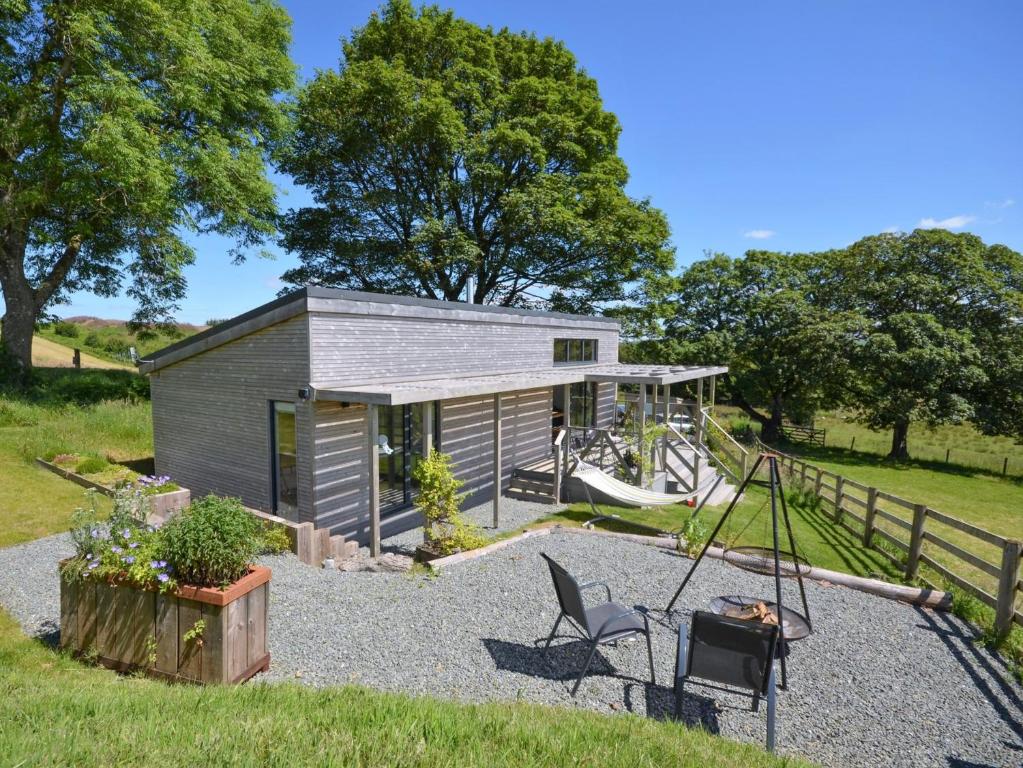 a tiny house with a swing in the yard at 1 Bed in Llandrindod Wells 53194 in Llandrindod Wells