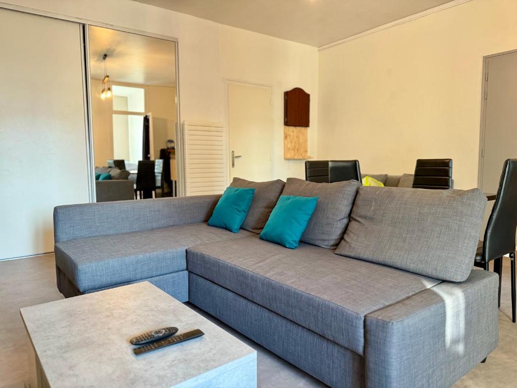 sala de estar con sofá gris y almohadas azules en Le Continental - Calme et Centre-Ville, en Aix-les-Bains