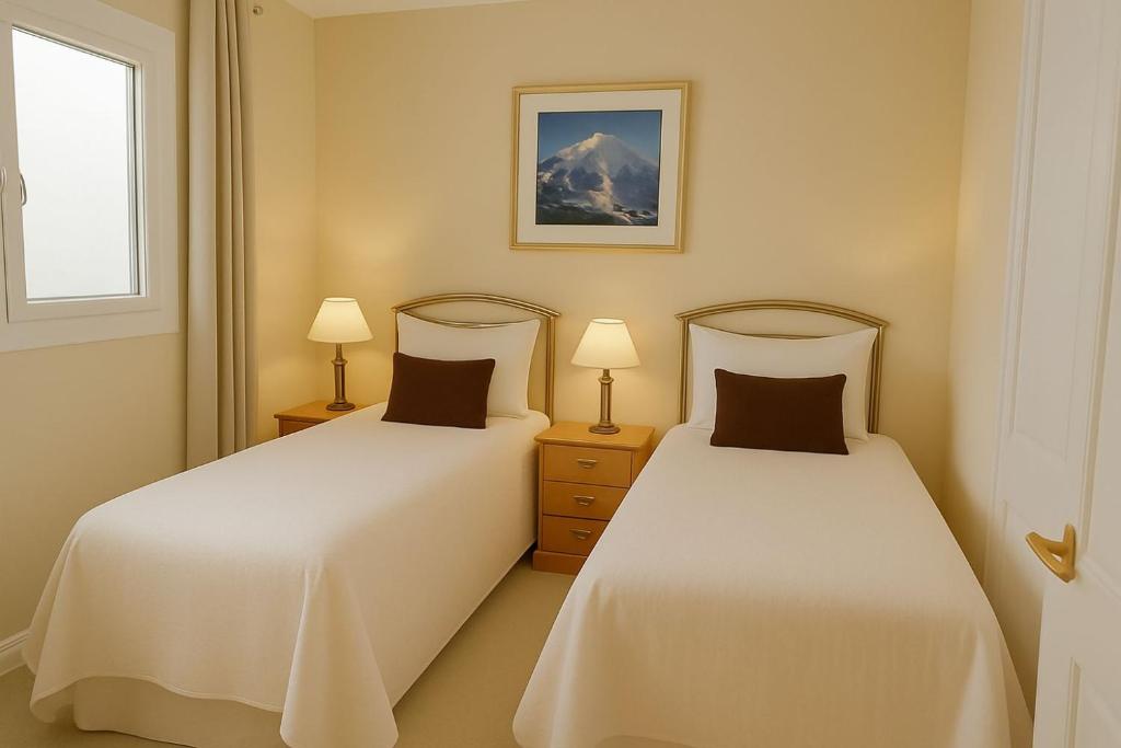 twee bedden in een kleine kamer met twee lampen bij Park City Suite in Park City