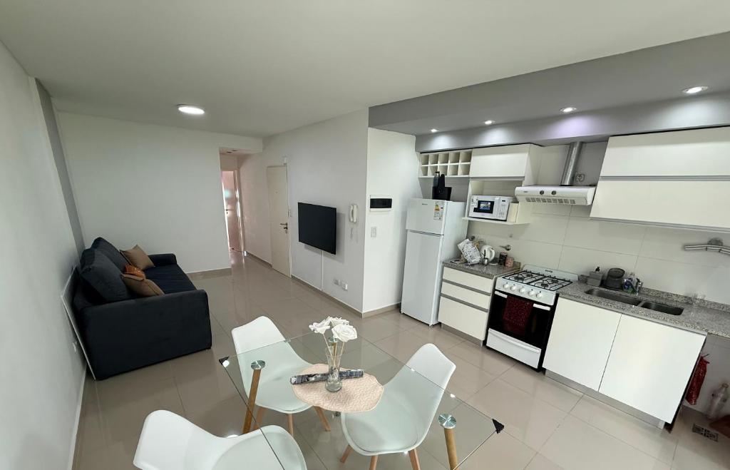 Una cocina y una sala de estar con mesa y sillas. en Las Lomitas Torre London, en Lomas de Zamora