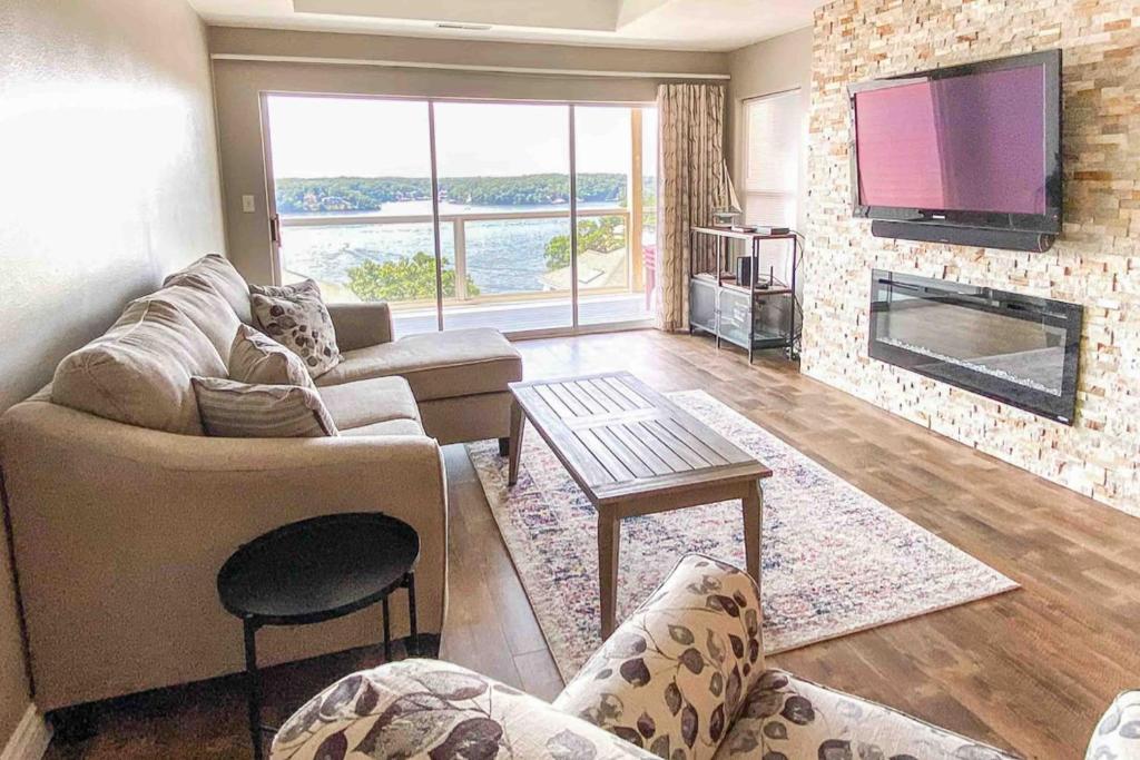 Una sala de estar con un sofá y un televisor. en The Calm at Emerald Bay, en Lake Ozark