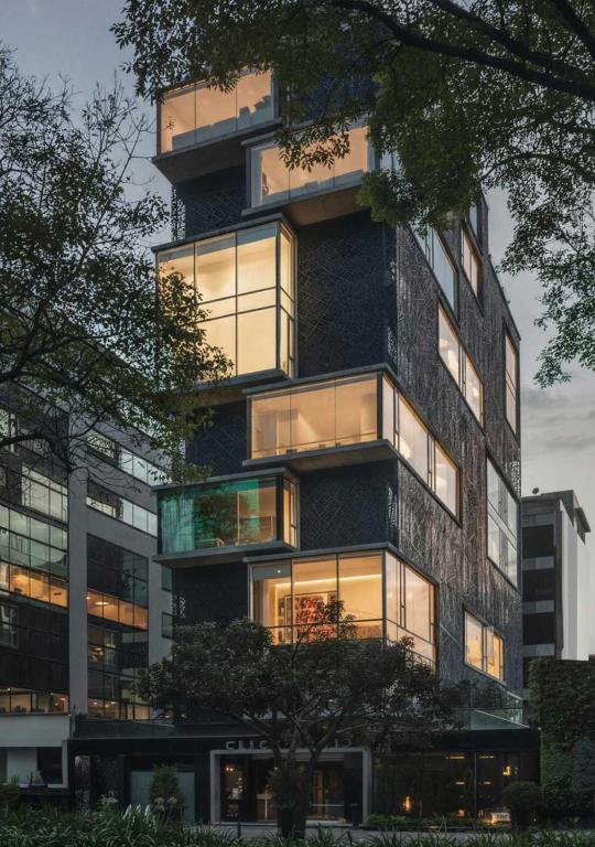 um edifício alto com muitas janelas em The Click Clack Hotel Bogotá em Bogotá
