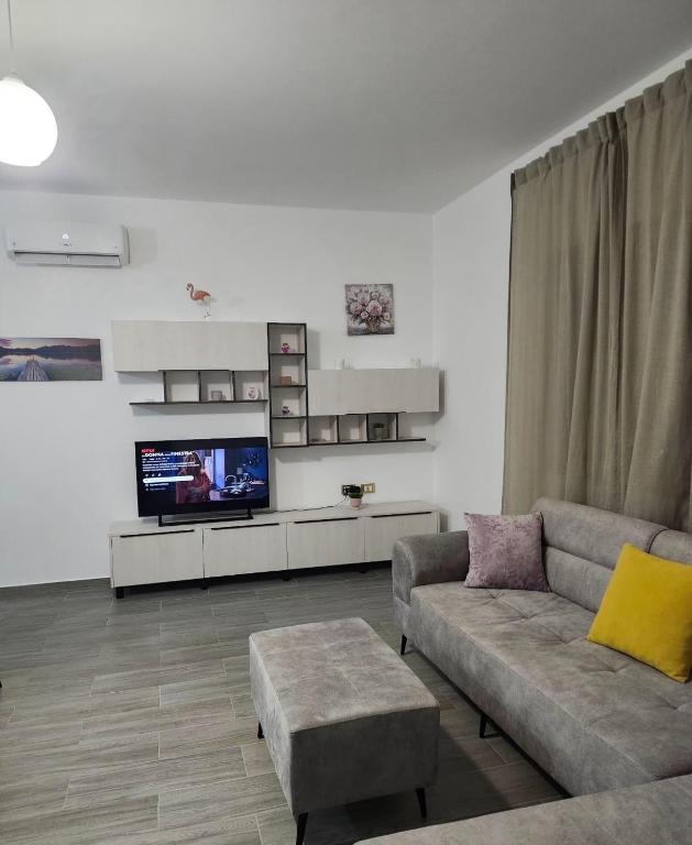 a living room with a couch and a tv at Albert's house for rent in Vlorë
