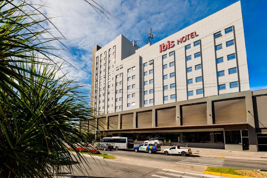 a big building with cars parked in front of it at ibis Navegantes Itajai in Itajaí