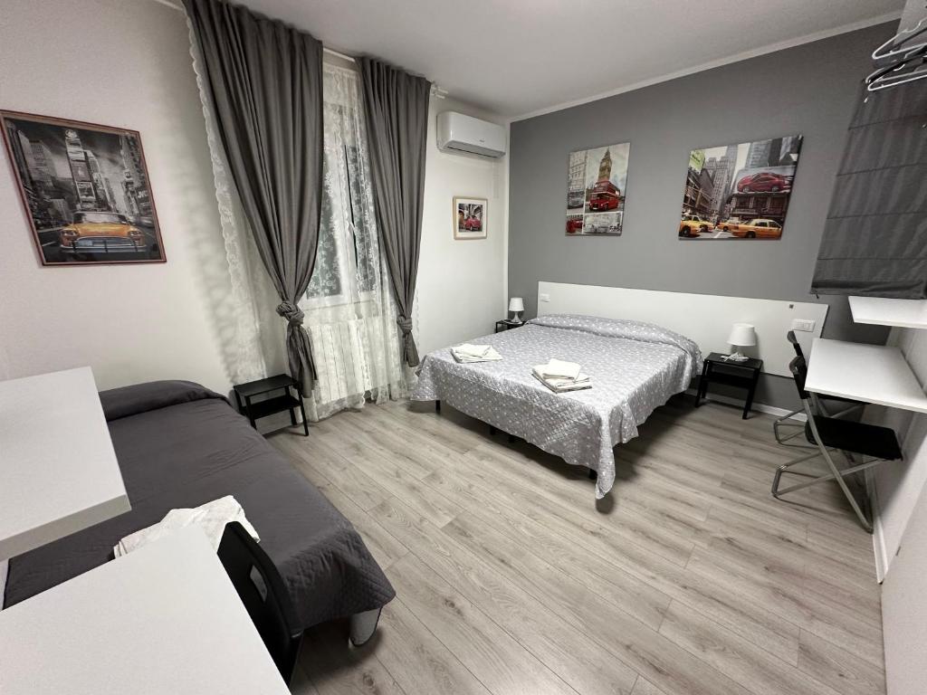 a hotel room with two beds and a desk at B&B Le Palme Fiera in Bologna
