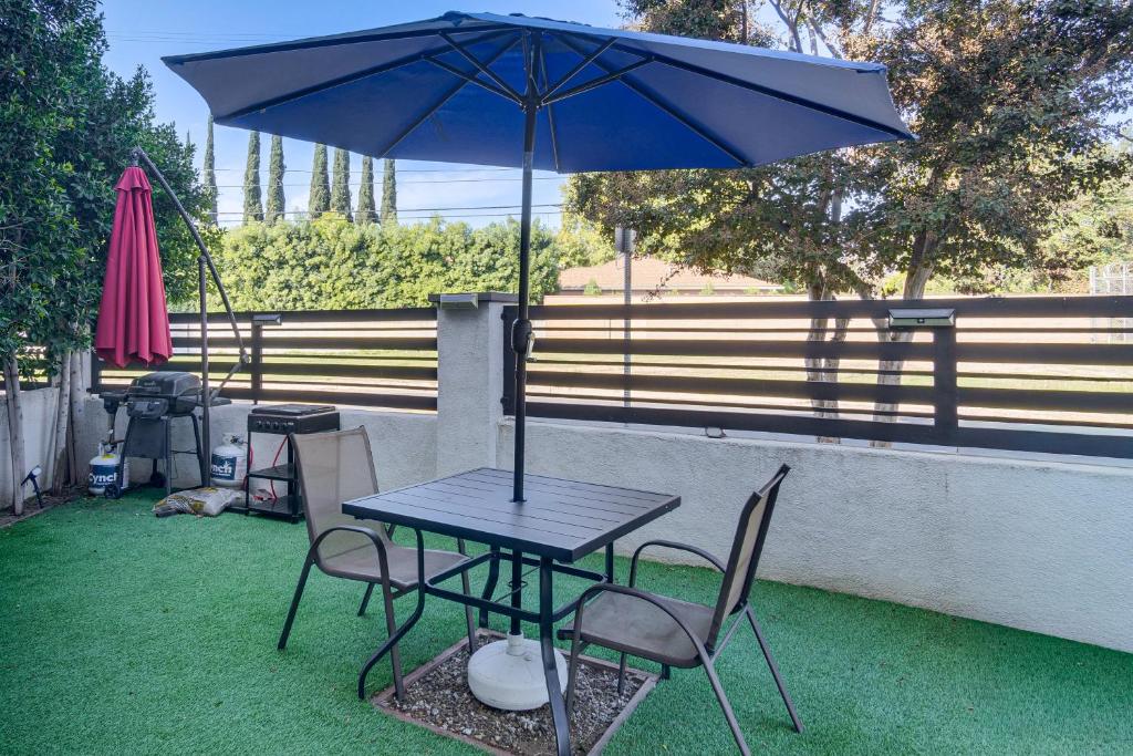 a table and chairs with an umbrella on the grass at Work and Play! North Hills Studio 15 Mi to Hollywood in North Hills