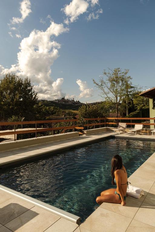 a young girl sitting in a swimming pool at CA'du LIN - Jacuzzi e Piscina in Cisterna dʼAsti