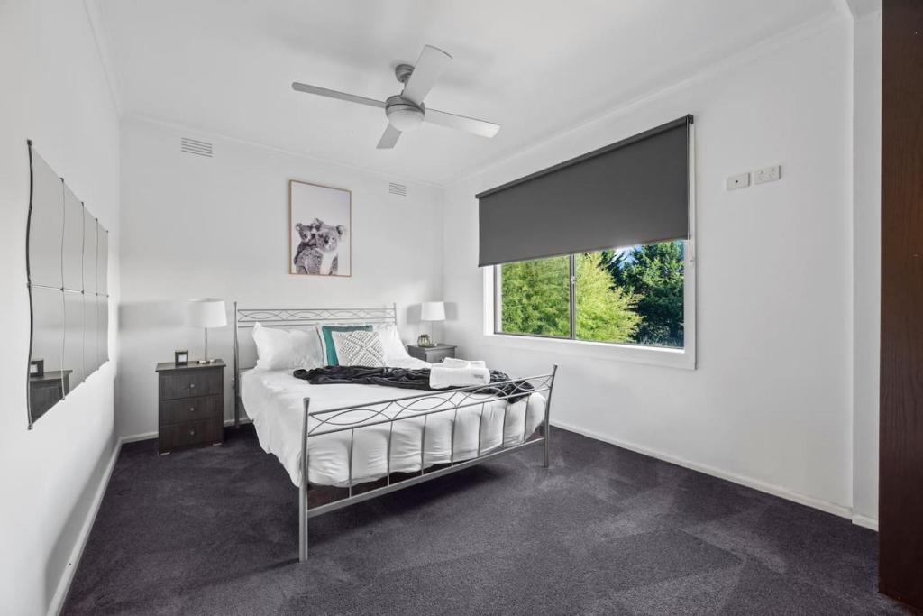 Relax Unwind in Berwick Multiple Retreat Walk to shops في بيرويك: غرفة نوم بيضاء مع سرير ونافذة