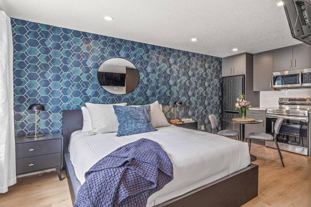 a bedroom with a large bed and a kitchen at Chick and Cozy Haven near Banff with Hot tub and Pool in Canmore