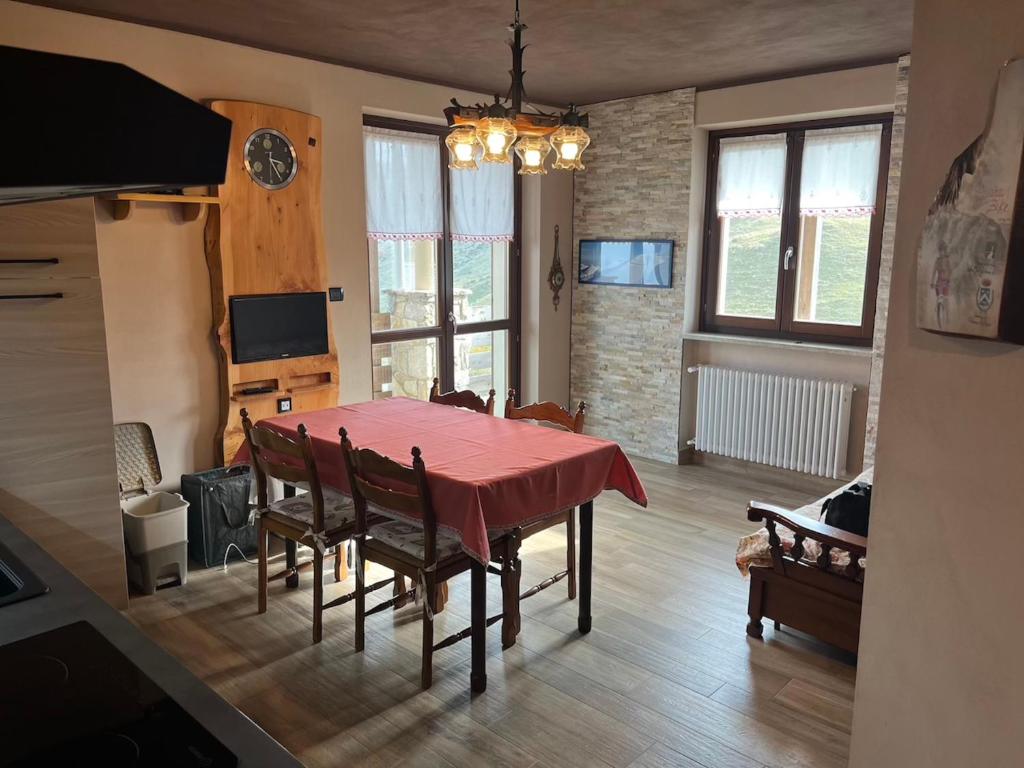a dining room with a red table and chairs at Holiday PratoNevoso - Sci ai piedi in Prato Nevoso