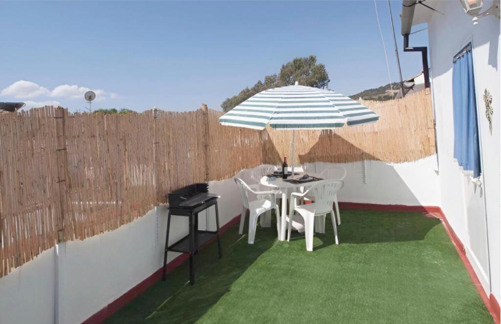 a patio with a table and chairs and an umbrella at Apartamentos de Salvadora I in El Bosque