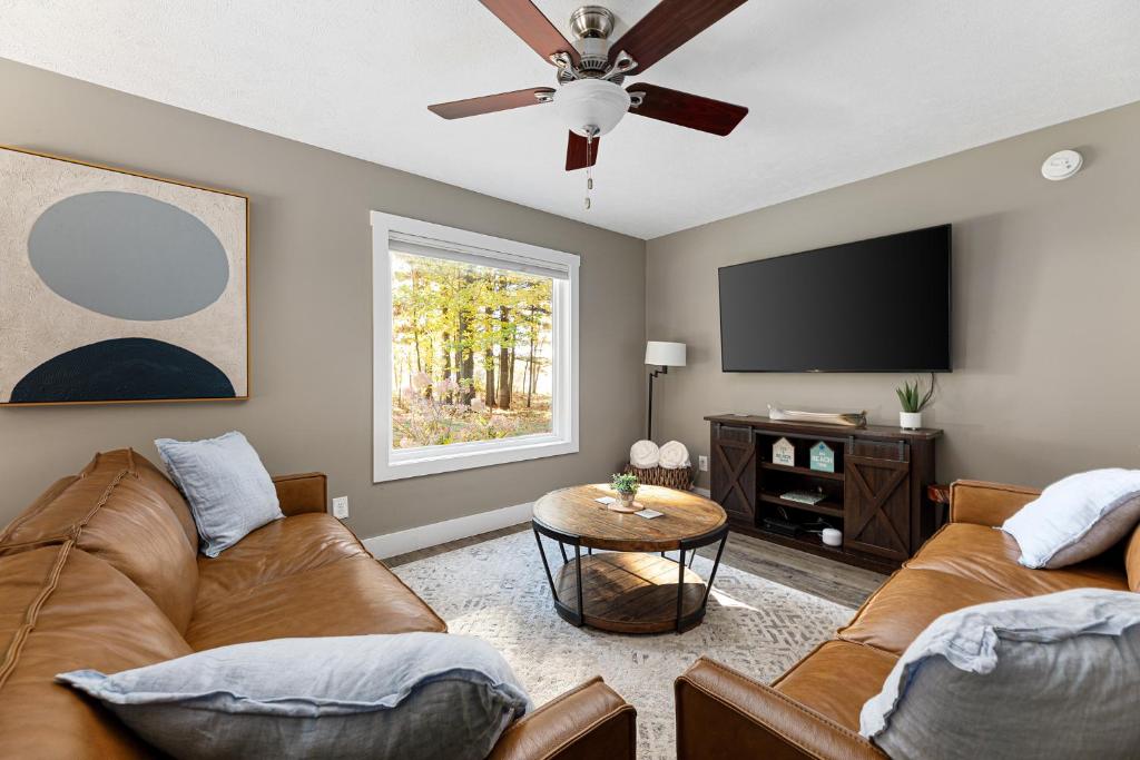 a living room with two couches and a flat screen tv at The Long Lake Escape in Traverse City