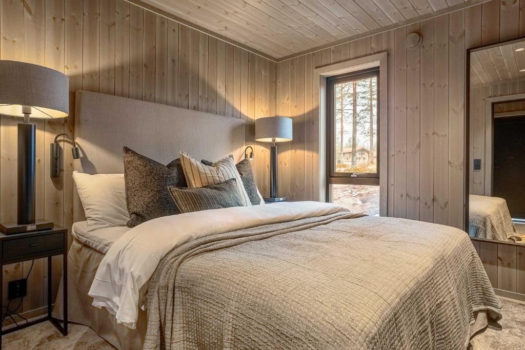 a bedroom with a large bed and two lamps at TH2115- Premium chalet in Trysilfjell with jacuzzi, sauna, shuttle bus in Trysil
