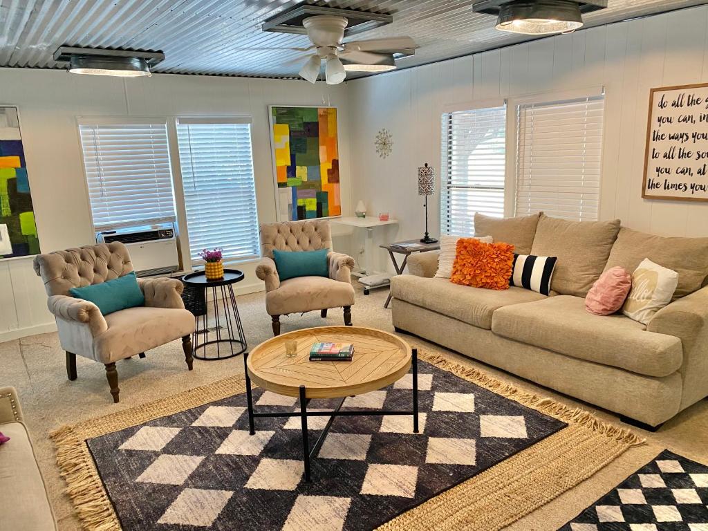 Una sala de estar con un sofá y sillas y una mesa. en Legacy Lodge, en Denison