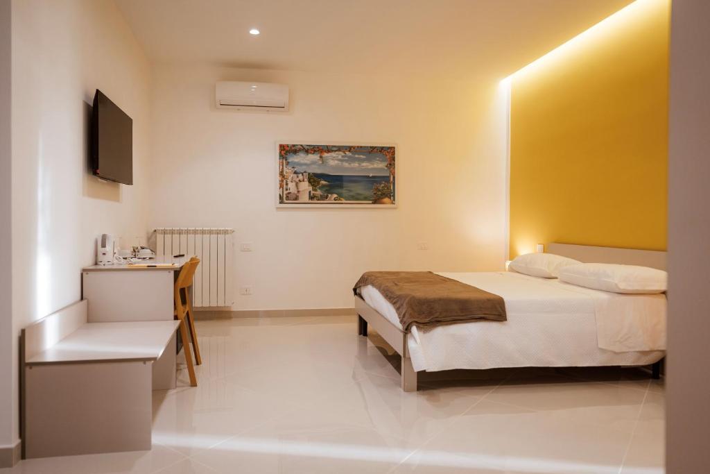 a bedroom with a bed and a desk and a television at Pantarei Palace in Lettere