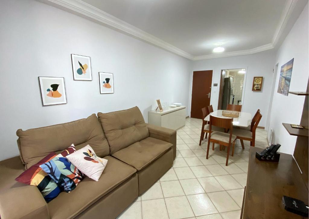 a living room with a couch and a dining room at Apartamento recantoazul es Conforto Total a 50m do Mar Apartamento Recém-Reformado na Praia de Castelhanos, ES, para 7 Pessoas Aconchegante e Completo, com 3 Quartos e 1 Suíte in Anchieta