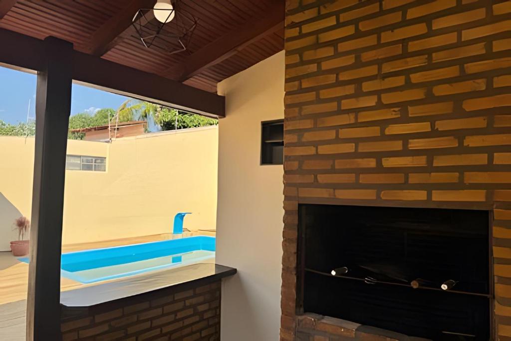 a fireplace in a living room with a brick wall at Casa com piscina para família em Bonito - Mato Grosso do Sul in Bonito