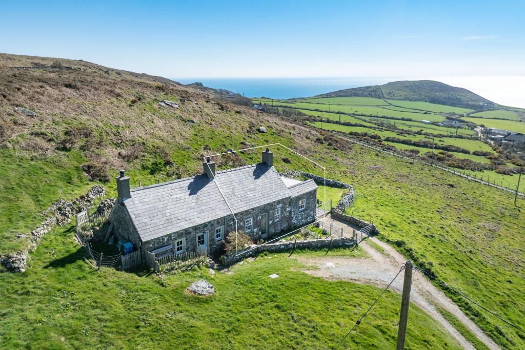 an old house on the side of a hill at 2-Bryn-Tirion in Rhiw
