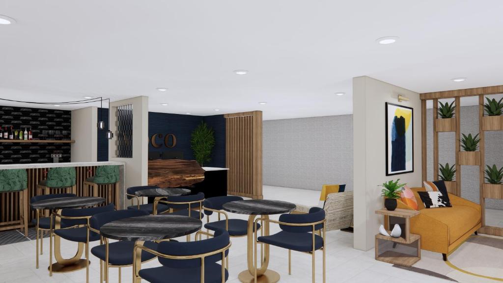 un bar con taburetes, mesa y sillas en voco Flagstaff by IHG, en Flagstaff