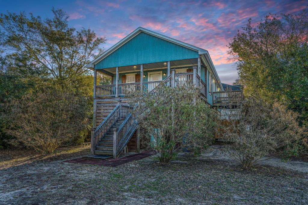 a large house with a blue roof and stairs at Serenity Now in Edisto Island