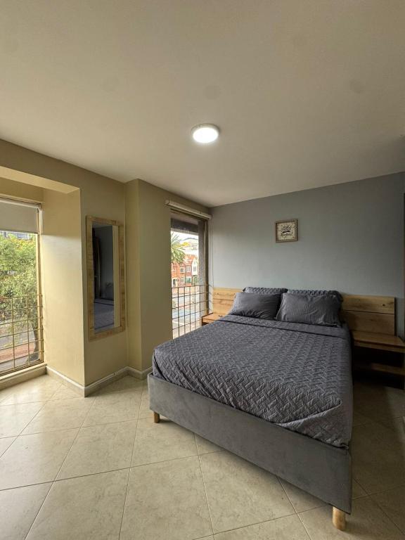 a bedroom with a bed and a large window at Hostelfc Movistar57 in Bogotá