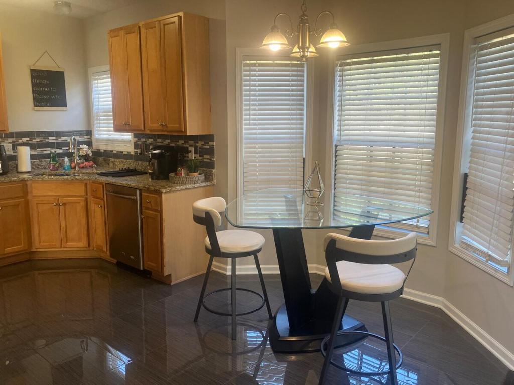 una cucina con tavolo in vetro e sedie bianche di Crestwicke Casa 75 a Jonesboro