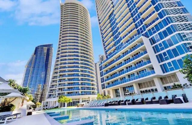 une piscine en face de certains grands bâtiments dans l'établissement 5-star, 3-bdrm apt on Surfers Paradise beach, à Gold Coast