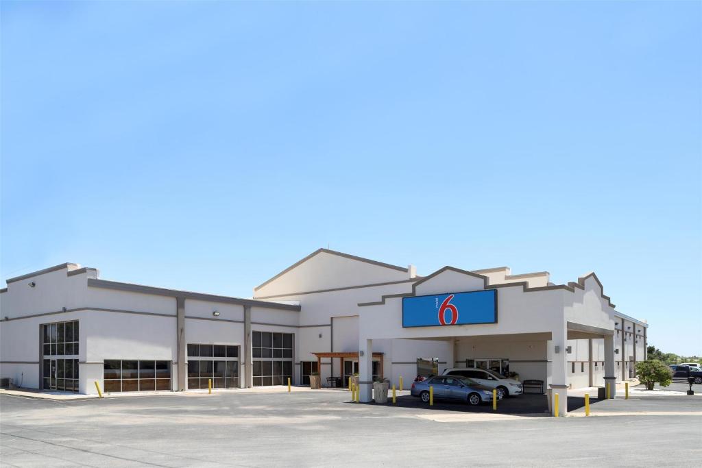 a building with a sign in a parking lot at Motel 6-Snyder, TX in Snyder