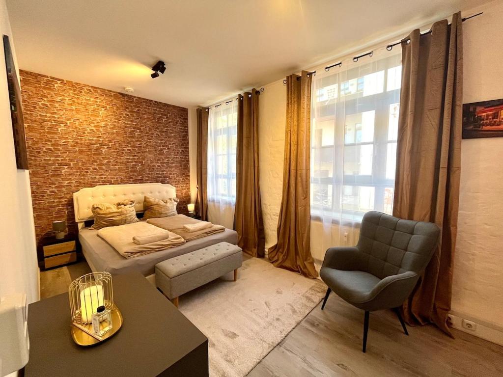 a bedroom with a bed and a chair and a window at Industrial feeling in a quiet location in Leipzig
