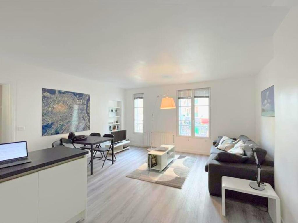 un soggiorno con un divano e un tavolo di La Clé de Pierre a Saint-Germain-en-Laye