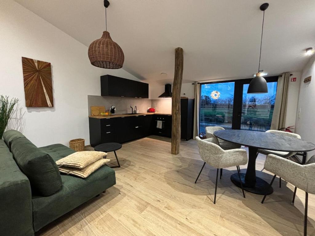 a living room with a green couch and a table at Le Marzelheide 2 in Lontzen