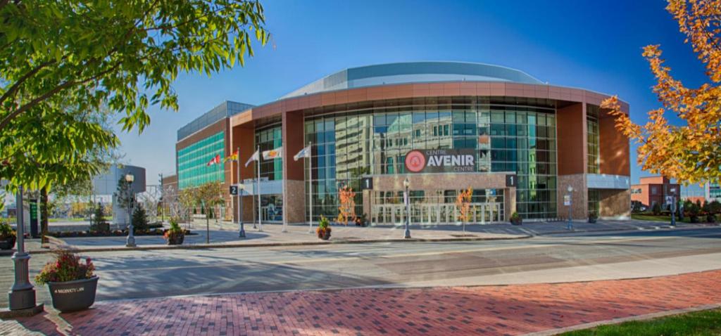a large building with a sign in front of it at Avenir Centre Suite - Near NBCC - SAVE on MONTHLY Stays in Moncton