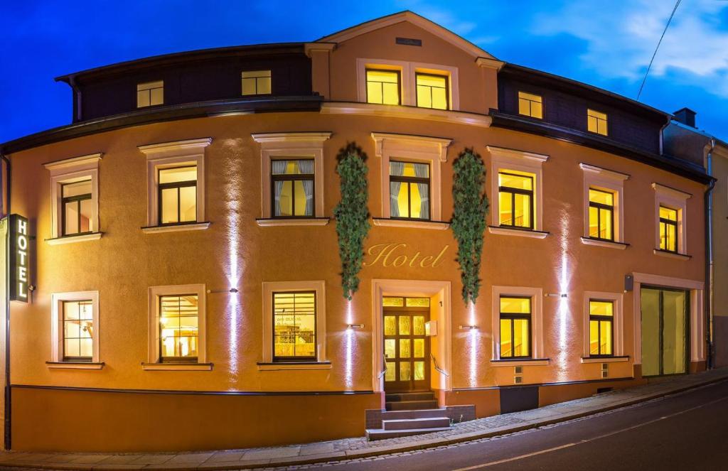 een groot gebouw met 's nachts verlichting bij Hotel Am Markt in Ehrenfriedersdorf