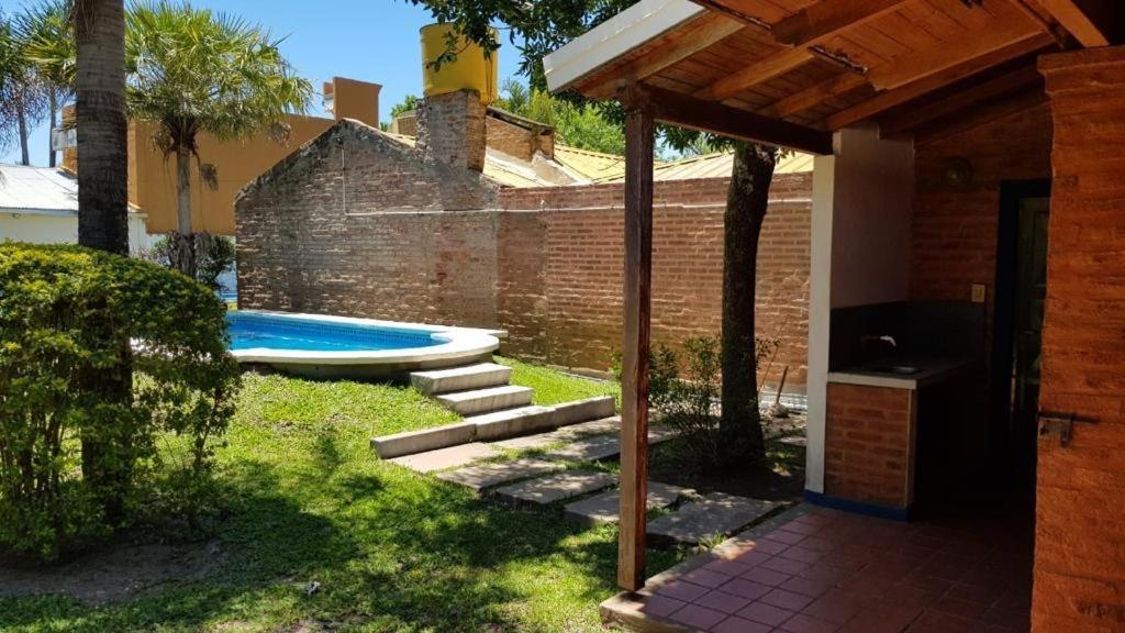 Un patio trasero con piscina y una casa. en Casaquinta con Piscina a Cuadras de la Playa, en Paso de la Patria