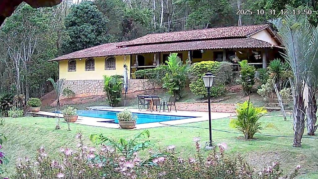 ein Haus mit einem Swimmingpool davor in der Unterkunft Suítes em Casa linda na Serra Paty do Alferes Rj in Paty do Alferes