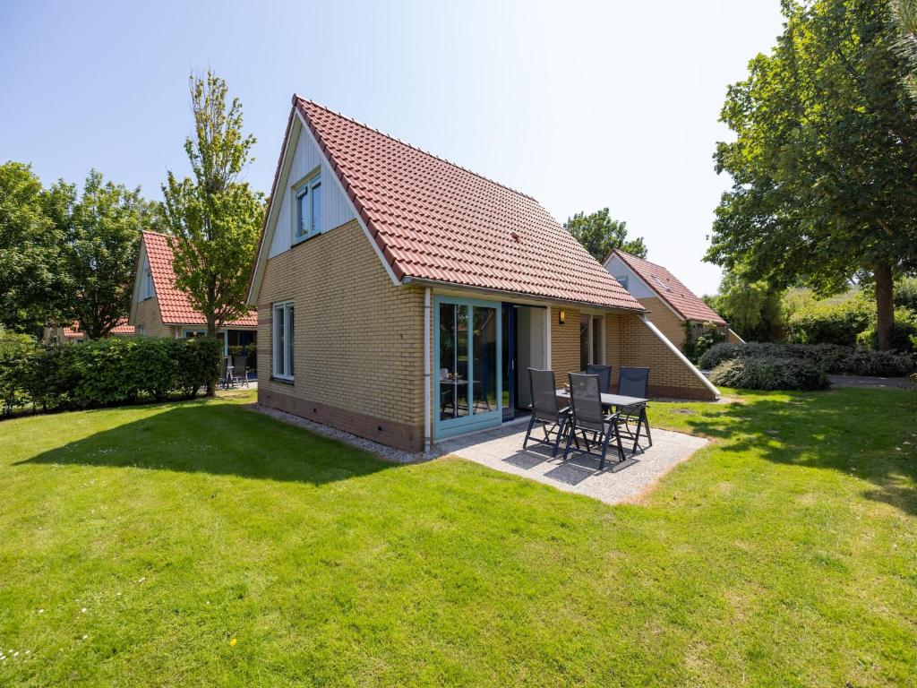 a small house with a table and chairs in a yard at Villa in Friesland with Garden by Water in Andijk