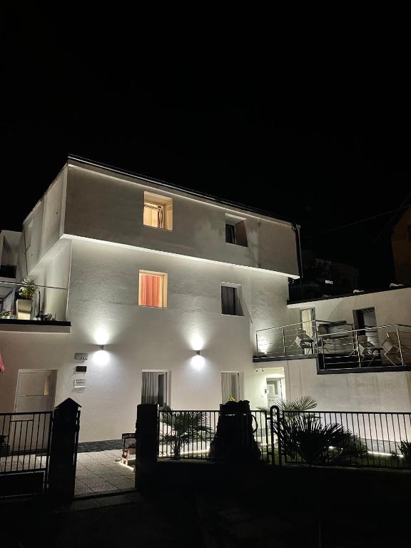 马里博尔Panda Rooms的白色的建筑,窗户和阳台,晚上