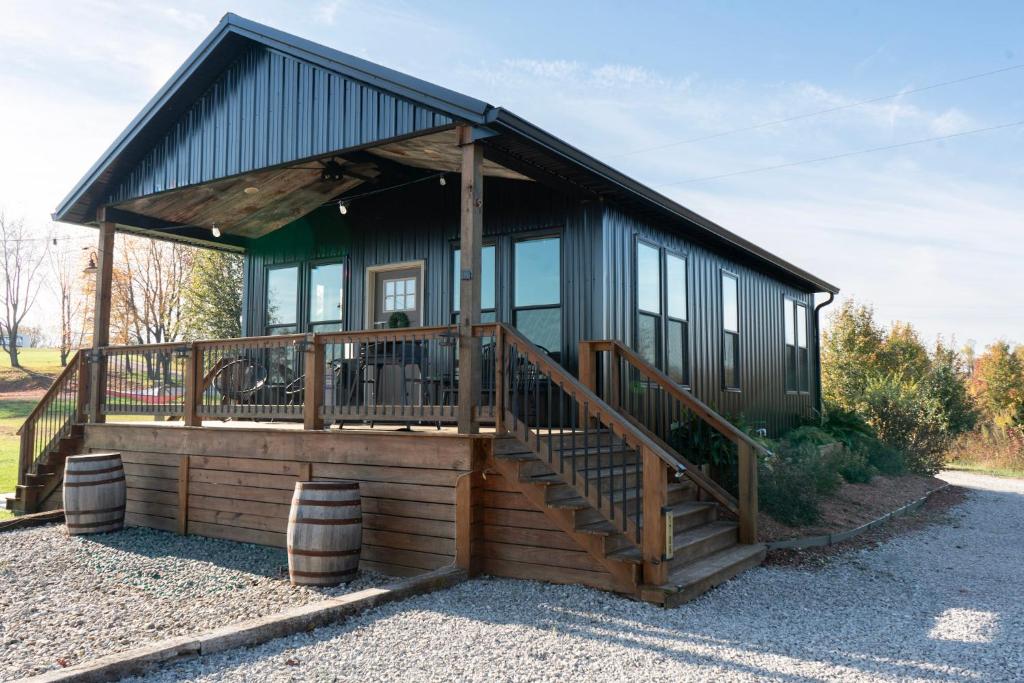 a house with a large deck with a porch at Bourbon Barrel Cottages #2 of 5 on Kentucky trail in Lawrenceburg