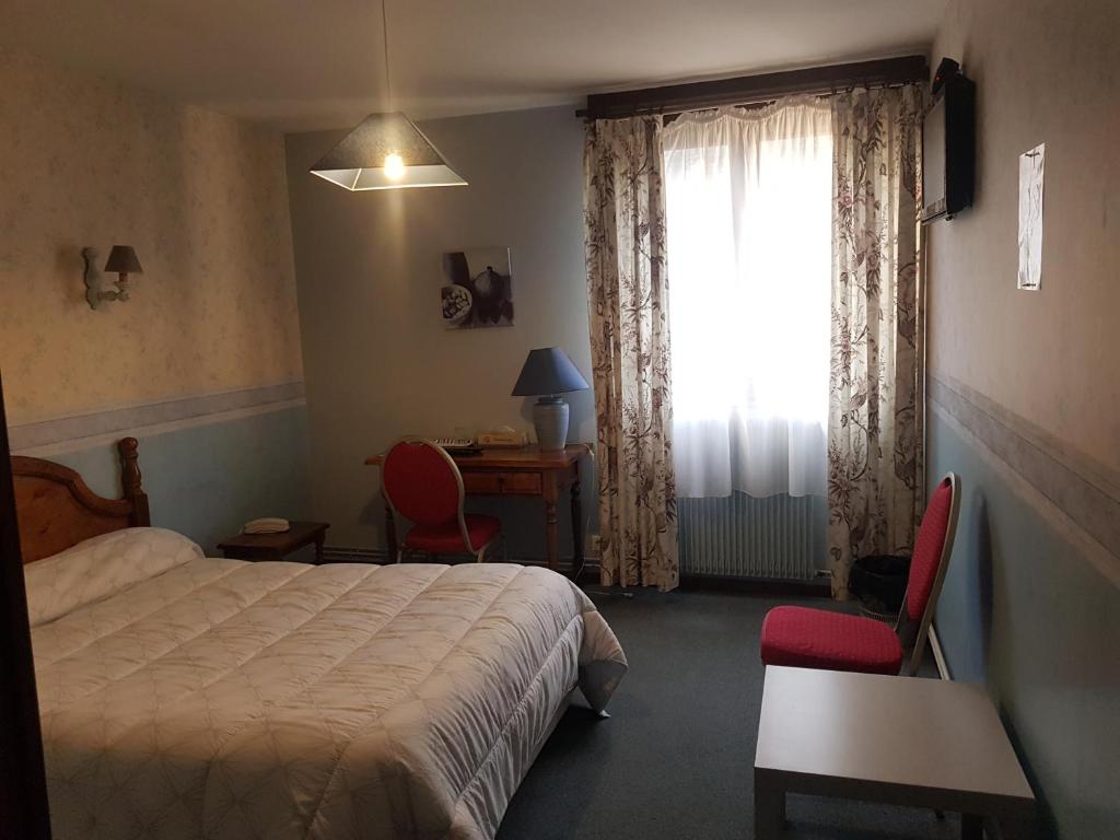 Ένα ή περισσότερα κρεβάτια σε δωμάτιο στο hôtel restaurant du cygne