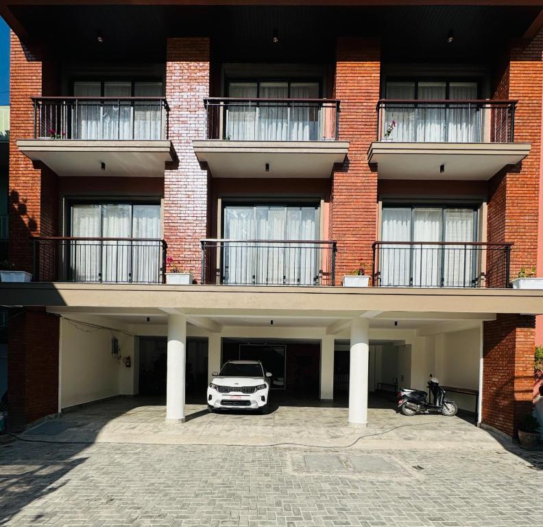 パタンにあるNavaya Residenceの建物の前の駐車場に駐車された車