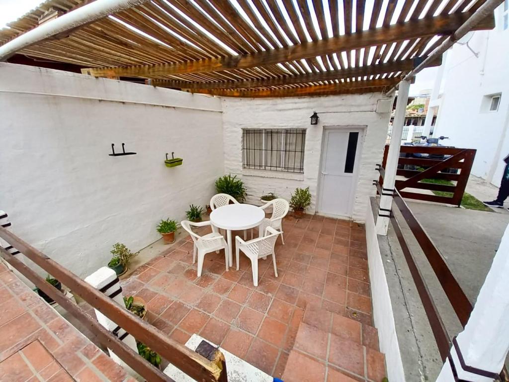 an outdoor patio with a white table and chairs at Complejo Antilhue in Las Grutas