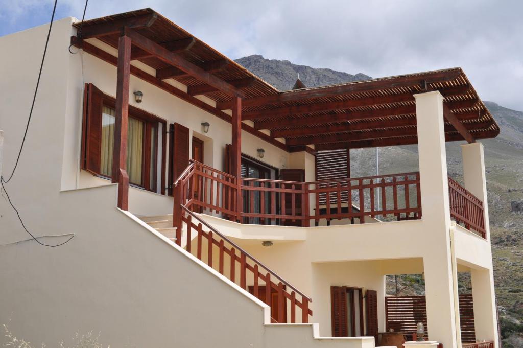 una casa con balcones de madera en un lateral en Villa Agalianos, en Kerames